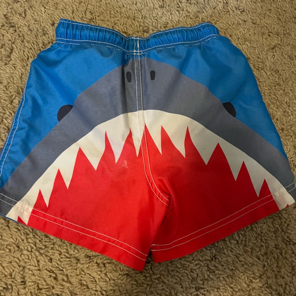 Mini Boden size 4-5 boys swim trunks. Small spot on the back of trunks